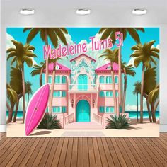 a pink building with palm trees and a surfboard on the floor in front of it