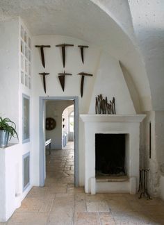 an archway leading to a living room filled with furniture and decor on either side of the fireplace