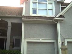 the front of a house with two garages and one car door in front of it