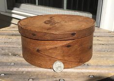 an old wooden box sitting on top of a table next to a window sill