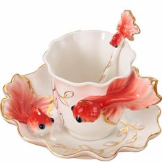 a cup and saucer with two gold fish on it