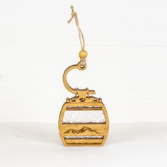 a wooden ornament with a ski lift on it's side hanging from a rope