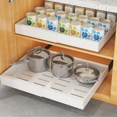 pots and pans are sitting on the shelf in this kitchen drawer organizer that is open