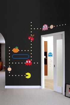 a room with an arcade game wall decal on the wall and door to another room