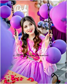 a girl in a pink dress is holding balloons