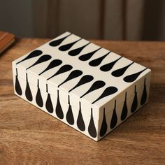 a box with spoons painted on it sitting on a table