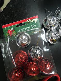 some shiny red balls are on the table next to scissors and other items that have been placed around them