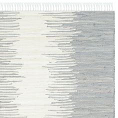 a white and grey rug with fringes on it