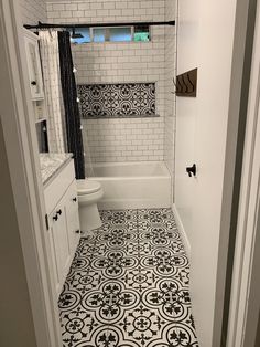 a bathroom with black and white tiles on the floor