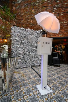 a table with an umbrella on top of it in front of a wall covered in money