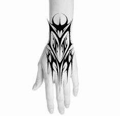 a hand with black and white tattoos on it's arm, showing the design