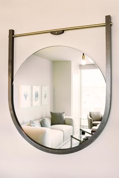 a mirror hanging on the wall above a couch