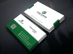 two green and white business cards sitting on top of a black table next to each other