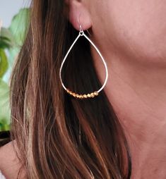 These large teardrop hoop earrings are an interesting twist in the standard. We have added some faceted gold beads to them for a fun modern mixed metal look! They are handmade from a high quality sterling silver wire hammered to hold their shape and give them shine. They slide easily onto your ear and are so lightweight you can hardly feel them! They won't weigh on your earlobe. Perfect for everyday! All items are gift wrapped and shipped without an invoice unless otherwise requested. Please let Silver Earrings Hoops, Gold And Silver Earrings, Tiny Necklace, Mixed Metal Earrings, Earrings Hoops, Teardrop Beads, Earrings Dainty, Solid Gold Jewelry, Metal Earrings