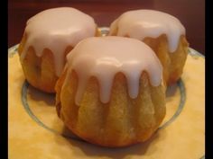 three donuts with icing sitting on a plate