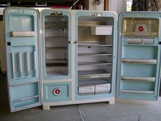 two old fashioned refrigerators sitting side by side in a garage with one open and the other closed