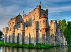 an old castle sitting next to a body of water