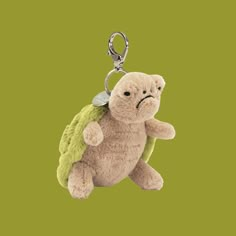 a stuffed turtle keychain hanging on a green background