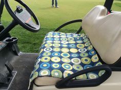 the driver's seat on a golf cart is covered with a blue and yellow polka dot fabric