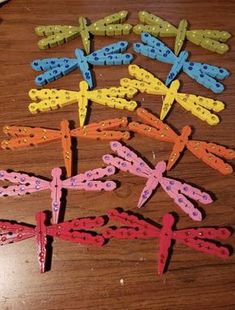 several different colored dragonflys on a table with holes in the middle to make them look like they are made out of paper