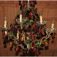 a chandelier hanging from the ceiling with many different colored beads and lights on it