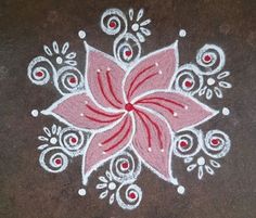 a red and white flower painted on top of a brown surface with circles around it