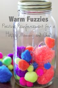 a glass jar filled with pom - poms on top of a wooden table