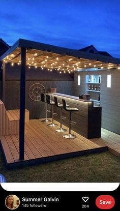 an outdoor bar with lights on the roof and some stools in front of it