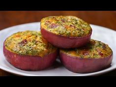 three cooked red potatoes on a plate with pesto and cheese in the middle, ready to be eaten