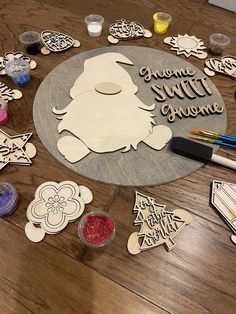 some cutouts are laying on the table with paint and markers in front of them