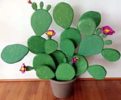 a potted plant with pink flowers in it on a wooden floor next to a wall