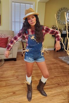 a woman in overalls and cowboy boots is standing on the floor with her arms outstretched