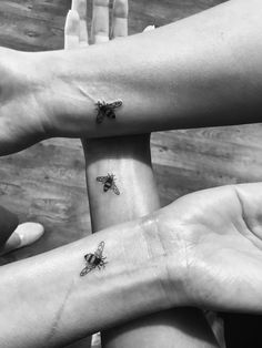 three people with matching tattoos on their arms