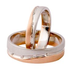 two gold and silver wedding rings with diamonds on each side, set against a white background