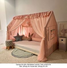 a child's bed with pink canopy and curtains