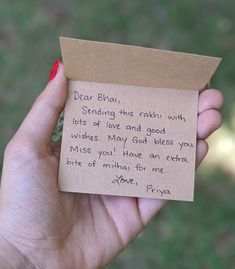 a hand holding a piece of paper with a note attached to it that says dear bhanj, sending this rabii with lots of love and good wishes