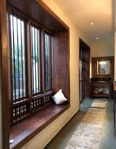 a long hallway with wooden windows and bars on the wall, along with tile flooring