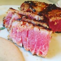 two pieces of meat sitting on top of a white plate