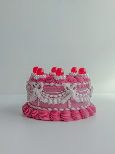 a pink and white cake sitting on top of a table