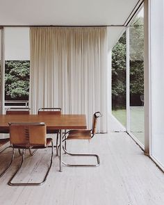 a dining room table and chairs in front of a sliding glass door