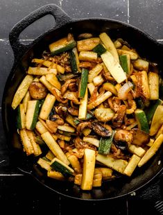 a skillet filled with vegetables on top of a stove