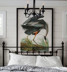 a bed with white sheets and a painting on the wall above it that has a bird painted on it