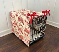 a dog crate wrapped in red and white fabric with a bow tied around the top