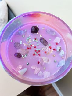 a purple bowl filled with lots of different colored rocks