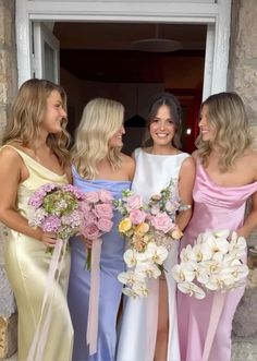 three beautiful women standing next to each other holding bouquets