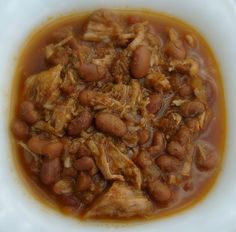 a white bowl filled with meat and beans