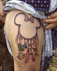 a woman's thigh with a mickey mouse tattoo on it