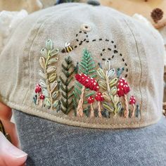 a person wearing a hat with embroidered designs on it