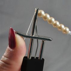 a person is holding a tiny lock with pearls on it