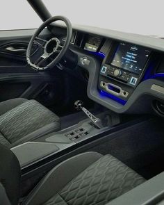 the interior of a car with black leather seats and blue lights on the dash board